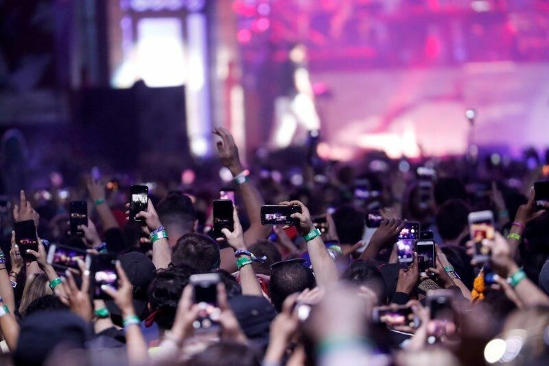 Para penonton konser menggunakan ponsel mereka merekam penampilan Eminem di Coachella 2018